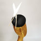 black sinamay pillbox hat with 2 floating feathers on mannequin head